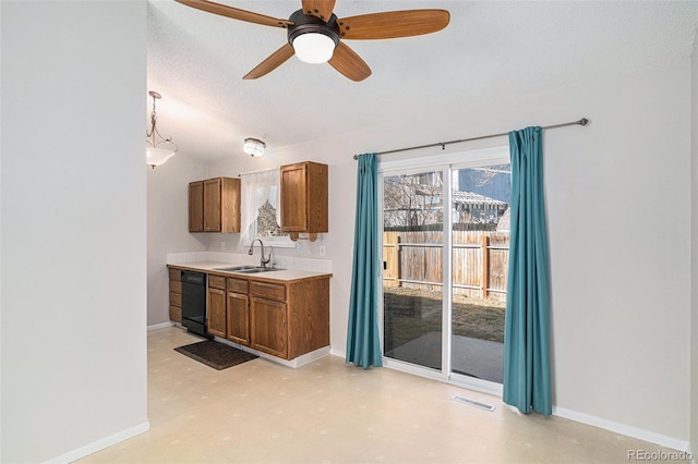 kitchen with a textured ceiling, ceiling fan, sink, decorative light fixtures, and black dishwasher