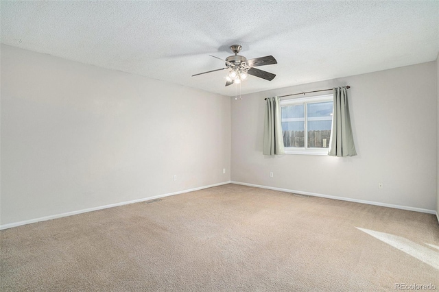 spare room with carpet flooring, a textured ceiling, and ceiling fan