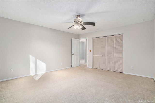 unfurnished bedroom with a textured ceiling, ceiling fan, and light carpet