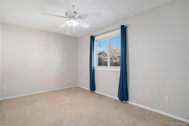 carpeted spare room with ceiling fan and a textured ceiling