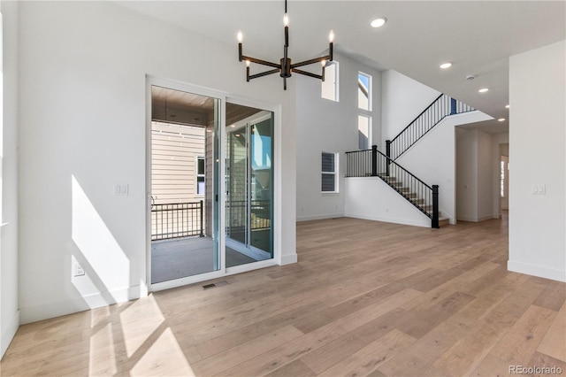5626 W 142nd Ave, Broomfield, CO 80020 - unfurnished living room featuring light wood-type flooring, recessed lighting, a chandelier, and stairs