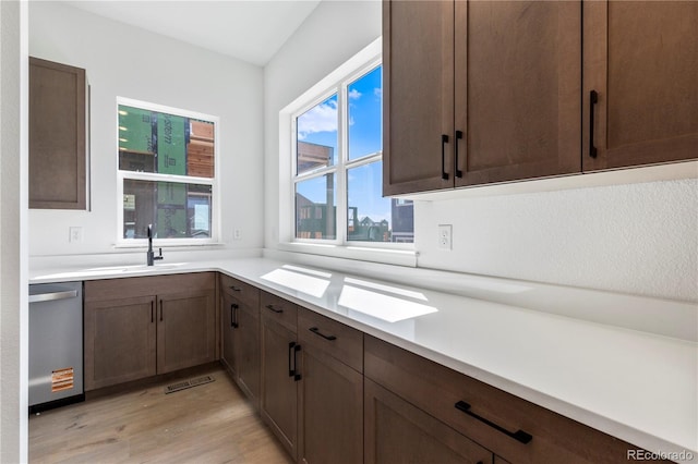 5626 W 142nd Ave, Broomfield, CO 80020 - kitchen with stainless steel dishwasher, light wood-type flooring, light countertops, and dark brown cabinetry
