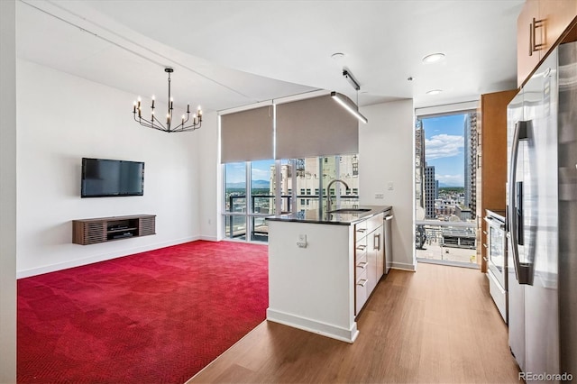891 14th St Unit 2105, Denver, CO 80202 - kitchen featuring appliances with stainless steel finishes, plenty of natural light, wood finished floors, floor to ceiling windows, and dark countertops
