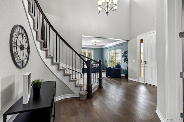 11522 Trona Ct, Parker, CO 80138 - foyer entrance with dark wood finished floors, stairway, baseboards, a high ceiling, and a chandelier