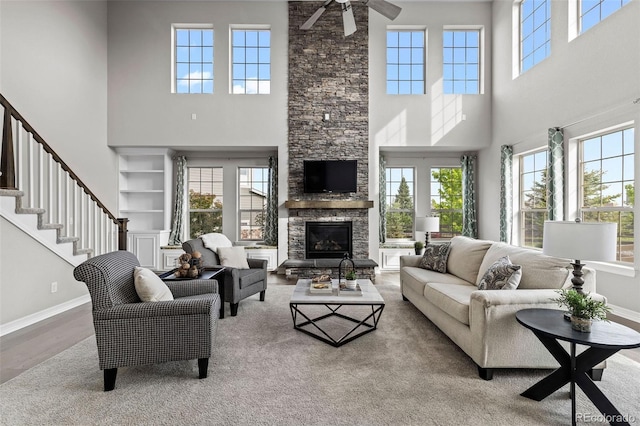 11522 Trona Ct, Parker, CO 80138 - living room featuring a towering ceiling, plenty of natural light, ceiling fan, baseboards, and a fireplace