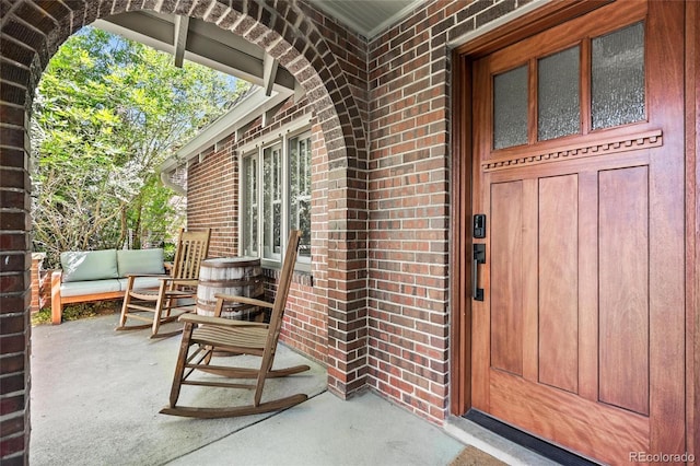 entrance to property featuring brick siding and a porch