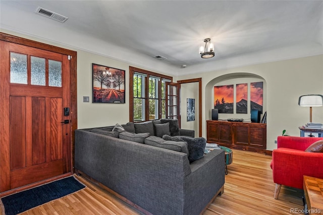 living room featuring light wood-style flooring and arched walkways