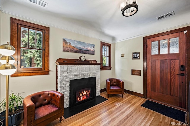 entrance foyer featuring wood finished floors, healthy amount of natural light, baseboards, and ornamental molding