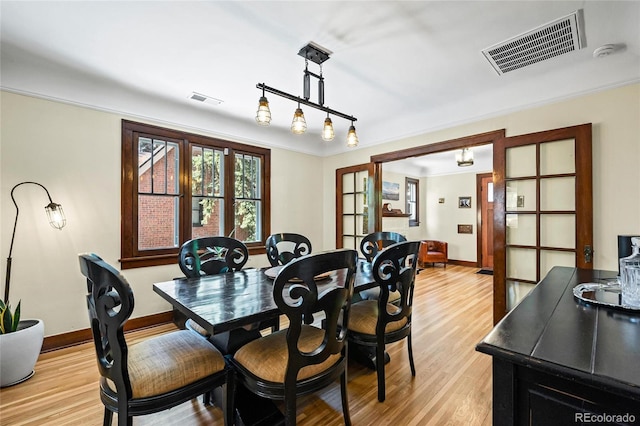 dining area featuring light wood finished floors and baseboards