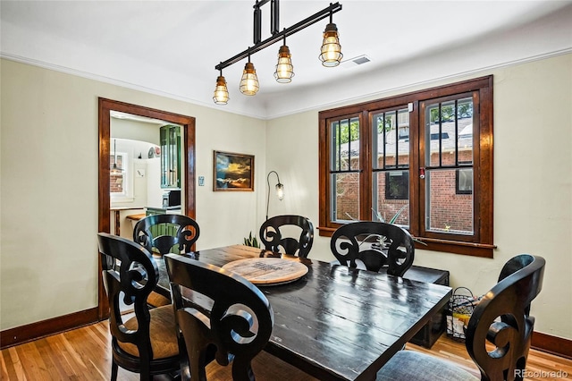 dining space featuring baseboards and wood finished floors