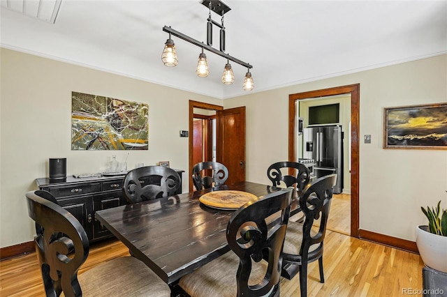 dining area featuring light wood finished floors and baseboards