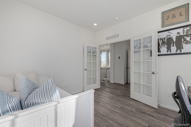 bedroom with hardwood / wood-style floors and french doors