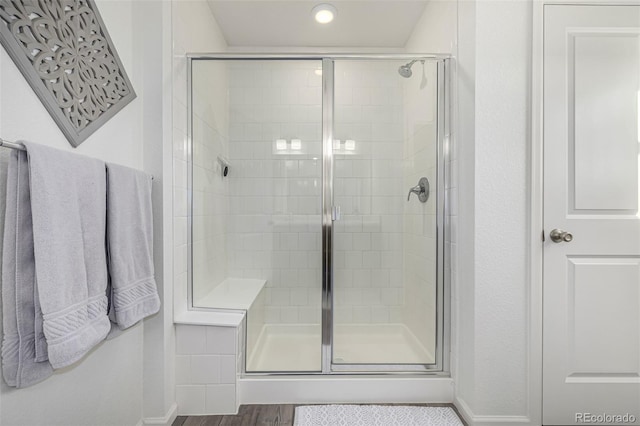 bathroom featuring an enclosed shower and wood-type flooring