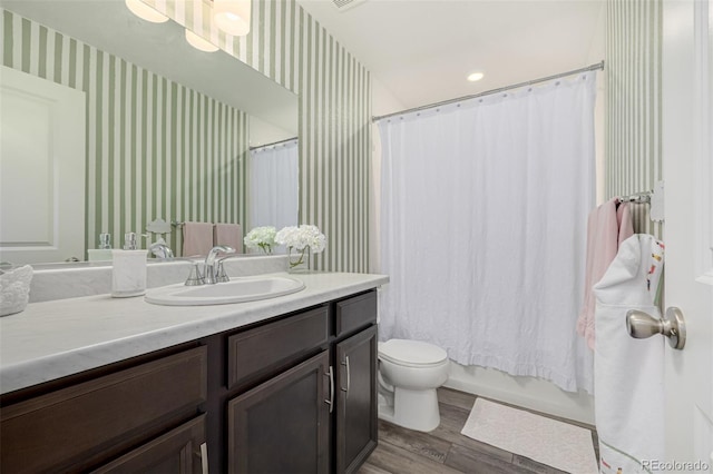 full bathroom featuring vanity, shower / tub combo with curtain, hardwood / wood-style flooring, and toilet