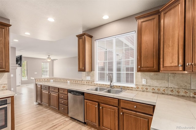 kitchen featuring light hardwood / wood-style floors, sink, stainless steel appliances, and backsplash