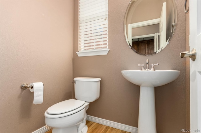 bathroom featuring sink, hardwood / wood-style floors, and toilet