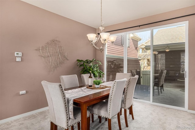 dining space featuring light carpet, an inviting chandelier, and baseboards