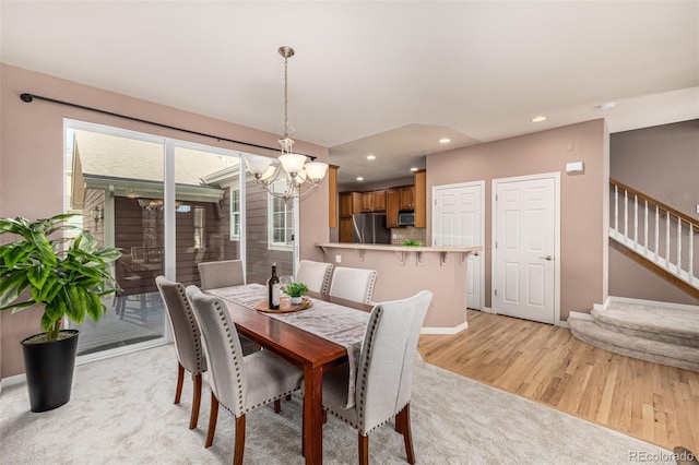 dining space featuring recessed lighting, light wood-style floors, a chandelier, baseboards, and stairs