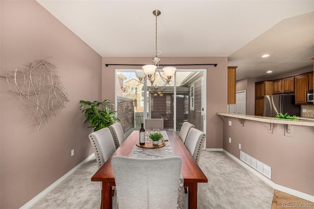 dining area with visible vents, light carpet, baseboards, and an inviting chandelier