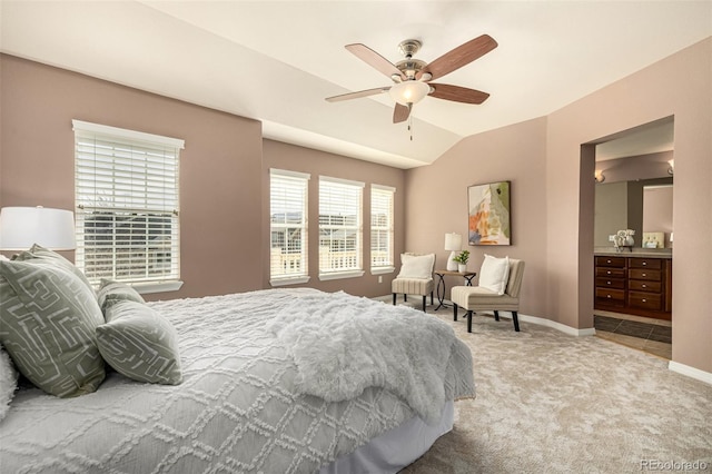 carpeted bedroom featuring connected bathroom, lofted ceiling, ceiling fan, and baseboards