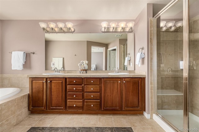 bathroom with double vanity, a stall shower, a sink, and tiled bath