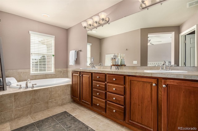 full bathroom featuring a bath, double vanity, visible vents, and a sink