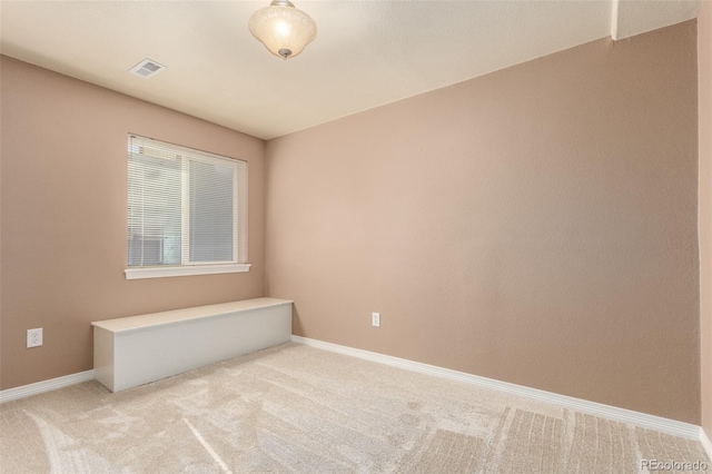 spare room featuring carpet floors, baseboards, and visible vents