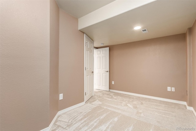 unfurnished room featuring light colored carpet, visible vents, and baseboards