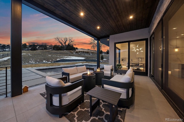 view of patio with an outdoor living space with a fire pit