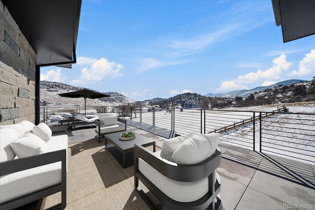 view of patio / terrace featuring a mountain view, an outdoor living space, and a balcony