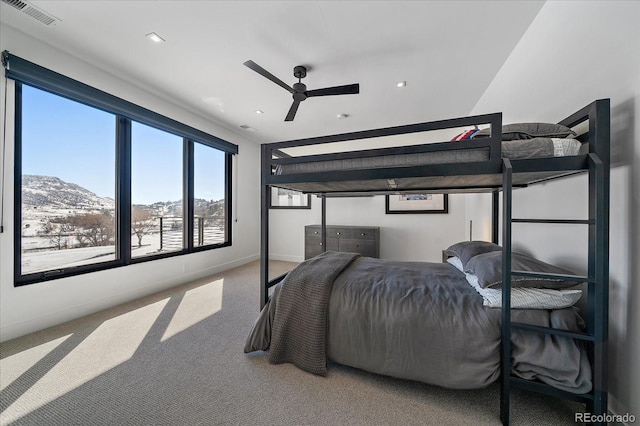 carpeted bedroom featuring a ceiling fan, visible vents, and baseboards