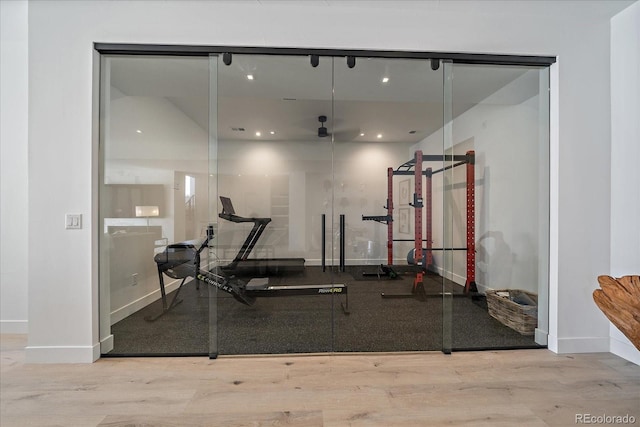 gym with baseboards and wood finished floors