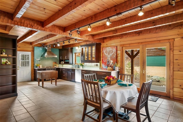 dining space featuring wooden walls, wood ceiling, rail lighting, and light tile patterned flooring