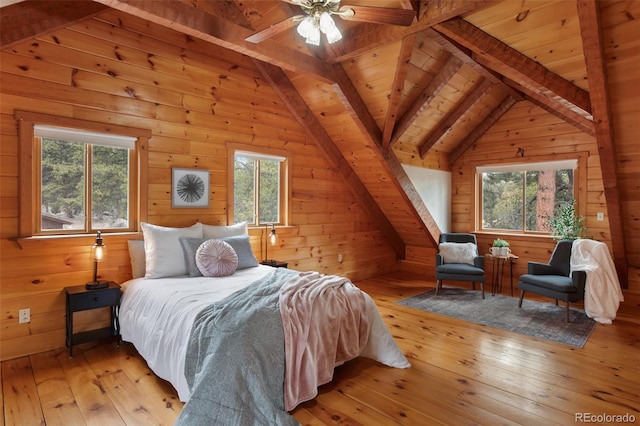 bedroom with wooden walls, multiple windows, and lofted ceiling with beams