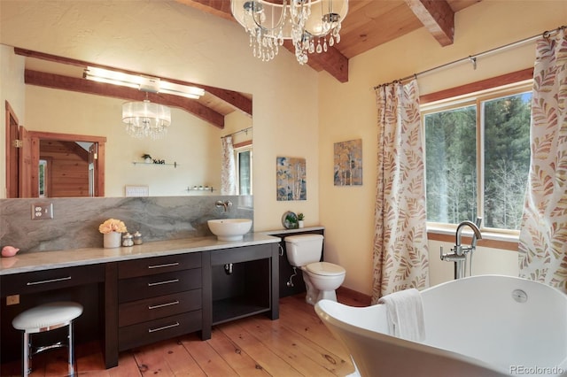 full bathroom featuring vanity, hardwood / wood-style floors, beamed ceiling, a freestanding bath, and a notable chandelier