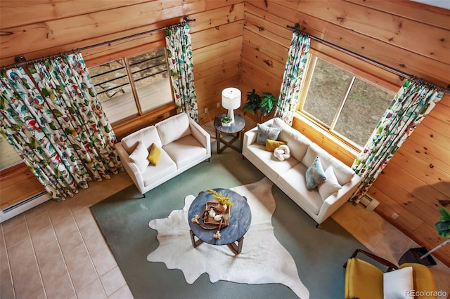 living area with tile patterned floors, a baseboard heating unit, and wood walls
