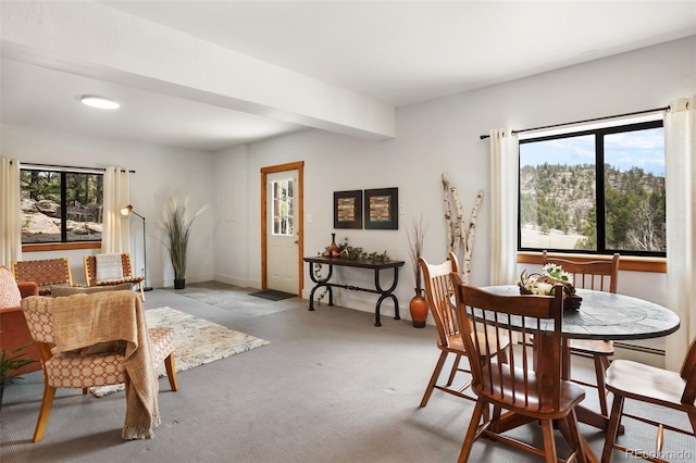 dining space with baseboards, light carpet, and a healthy amount of sunlight