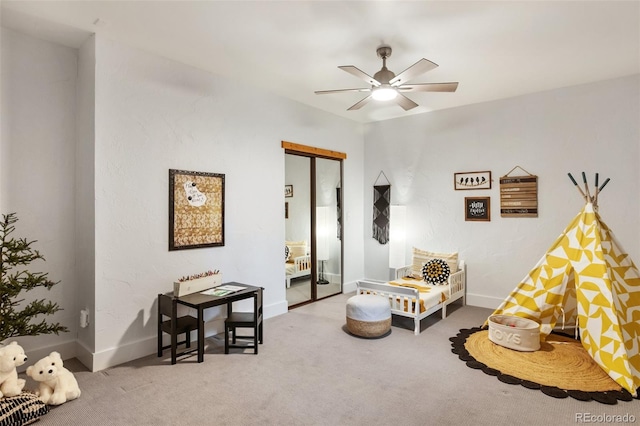 living area featuring carpet flooring, a ceiling fan, and baseboards