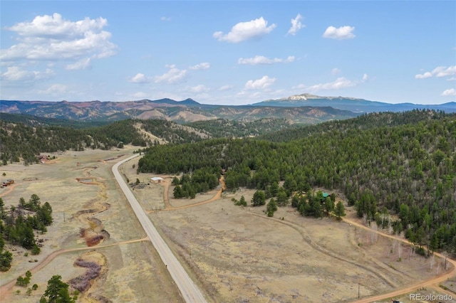 drone / aerial view featuring a view of trees and a mountain view