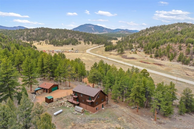 drone / aerial view featuring a view of trees, a mountain view, and a rural view