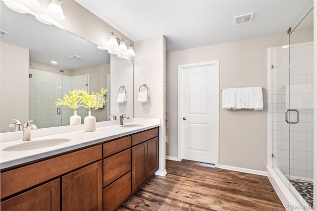 18077 E 99th Ave, Commerce City, CO 80022 - bathroom featuring double vanity, a shower stall, wood finished floors, and baseboards