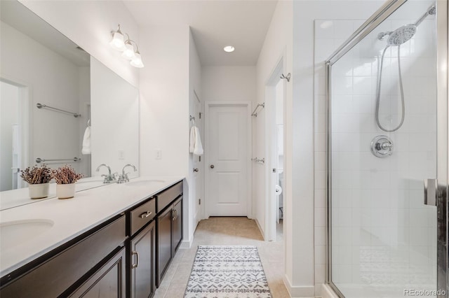 8517 Eckley St, Littleton, CO 80125 - full bathroom featuring double vanity, a shower stall, tile patterned floors, toilet, and recessed lighting