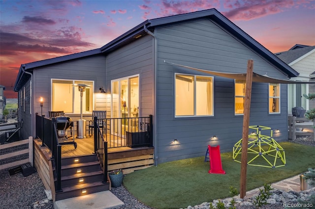 8517 Eckley St, Littleton, CO 80125 - back of property at dusk with a wooden deck and a lawn