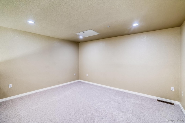 spare room with carpet, recessed lighting, a textured ceiling, and baseboards