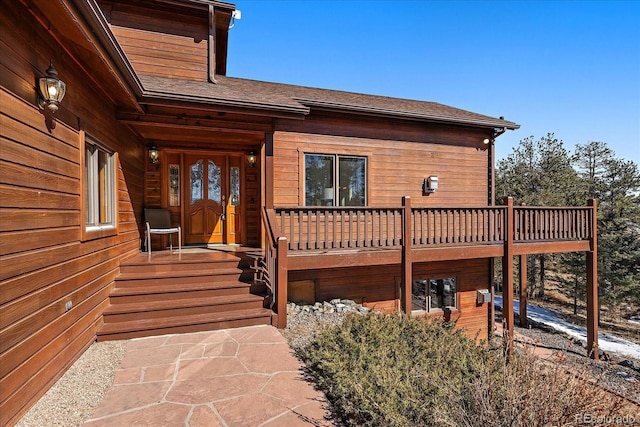 doorway to property featuring a shingled roof