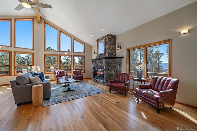 living room featuring a wealth of natural light, a fireplace, high vaulted ceiling, and hardwood / wood-style floors