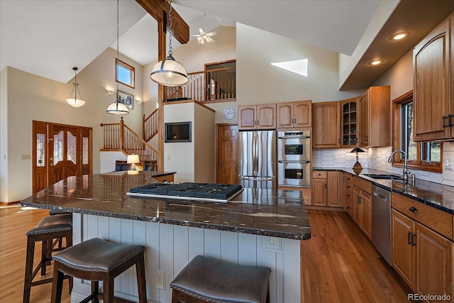 kitchen with a spacious island, plenty of natural light, appliances with stainless steel finishes, and a sink