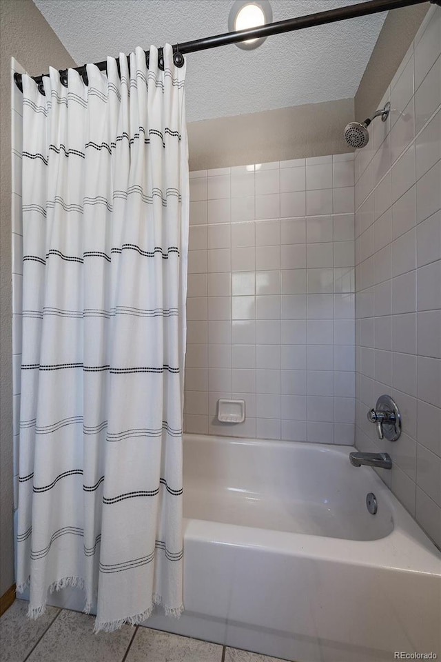 bathroom with shower / bath combo with shower curtain, a textured ceiling, and tile patterned floors