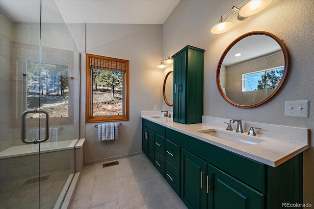 full bathroom with a stall shower, visible vents, a sink, and double vanity