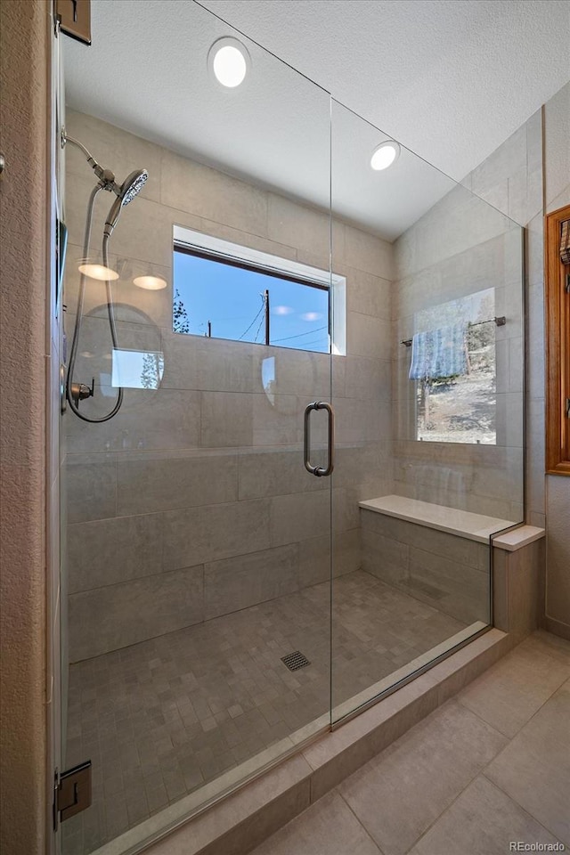 full bathroom with a stall shower and tile patterned flooring